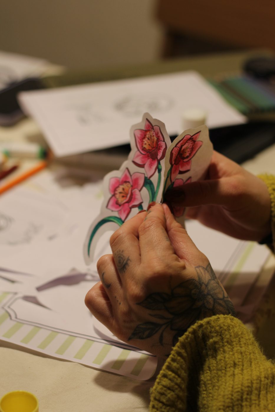 Manos armando un florero de papel